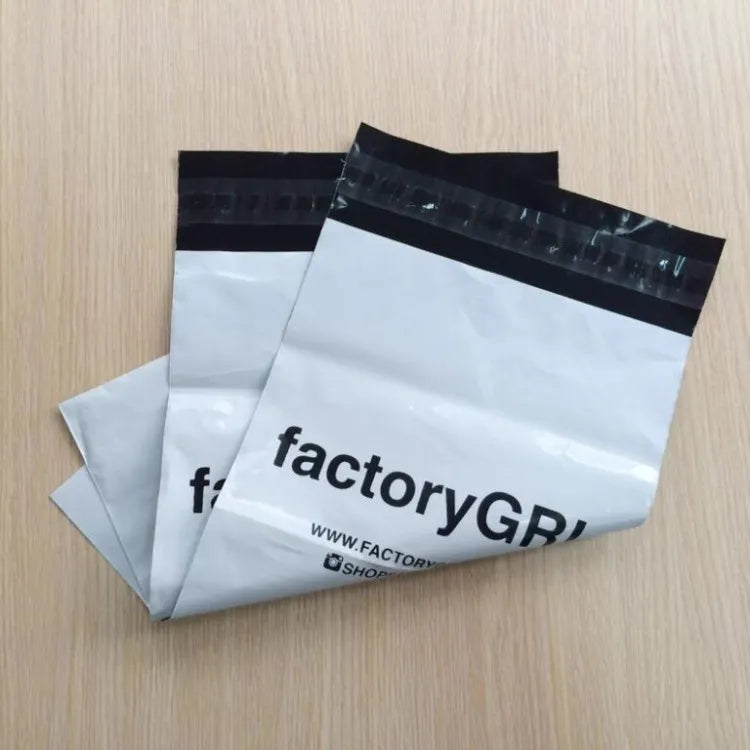 Gray plastic mailer bags printed with dark brand lettering and black closure flaps