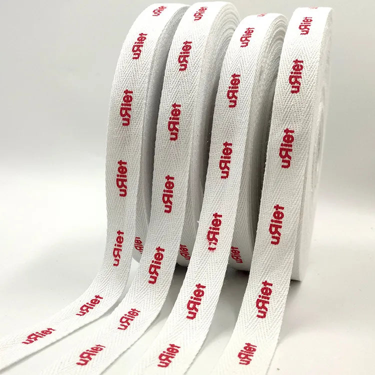 White cotton twill tape roll with repeating red custom printed logos for garment branding