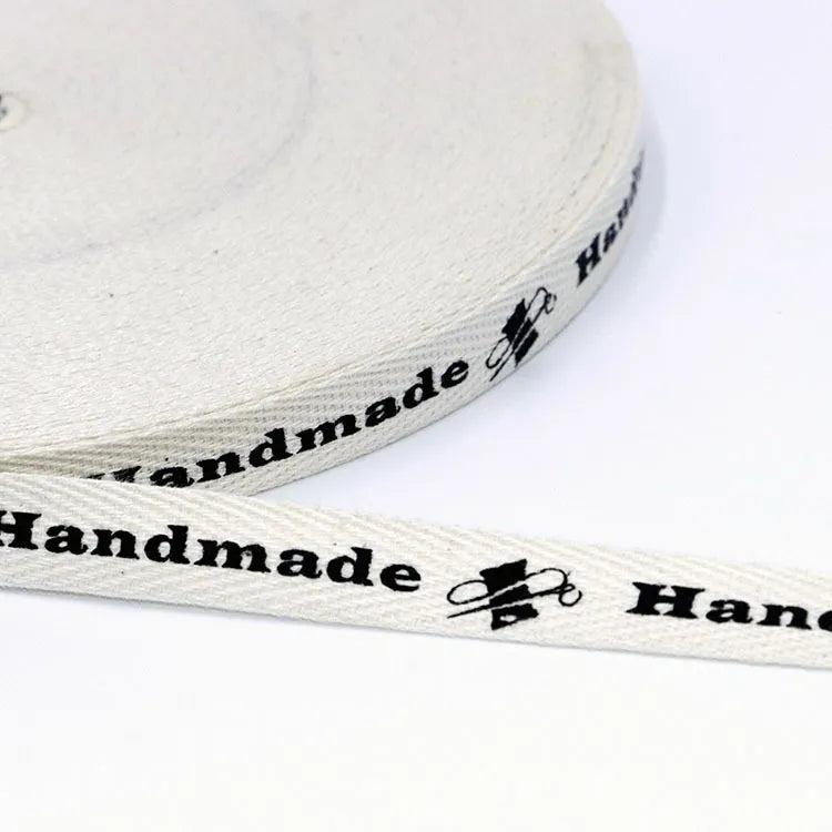 White herringbone cotton twill tape roll printed with Handmade text and vintage sewing machine emblem