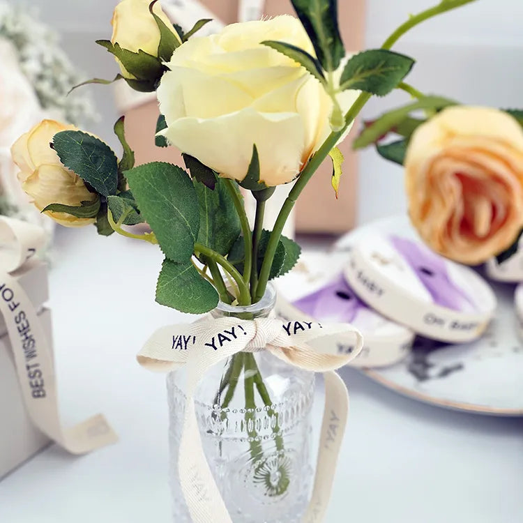 Decorative floral arrangement tied with a custom printed cotton ribbon bow for gift presentation