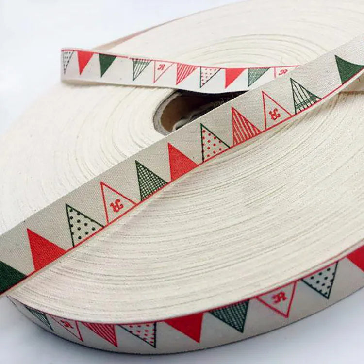 Spool of cream cotton ribbon printed with festive multicolor pennant bunting flag patterns