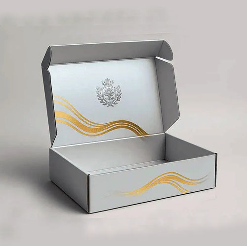 Open silver-colored mailer box with gold wave graphics and a crest printed inside the lid