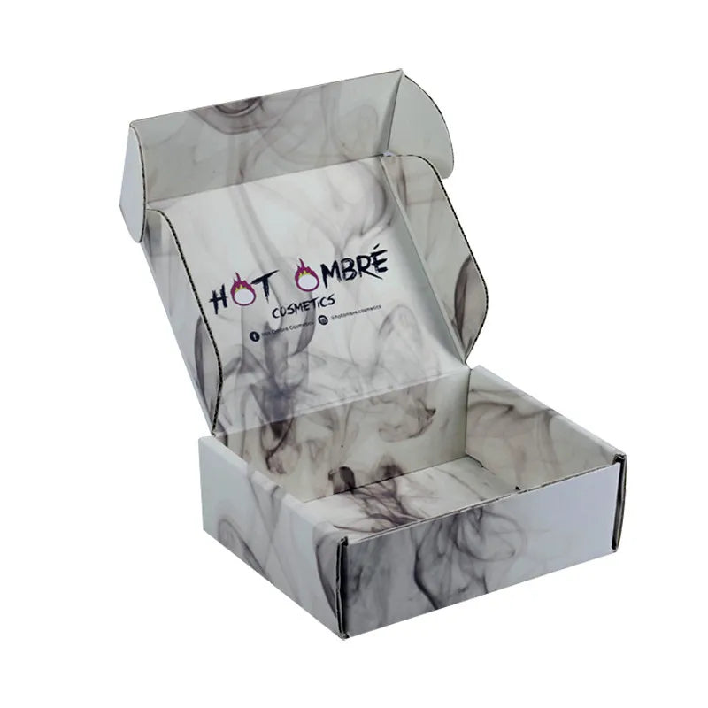 Open white mailer box with smoky gray printing inside and outside and a cosmetics logo inside the lid