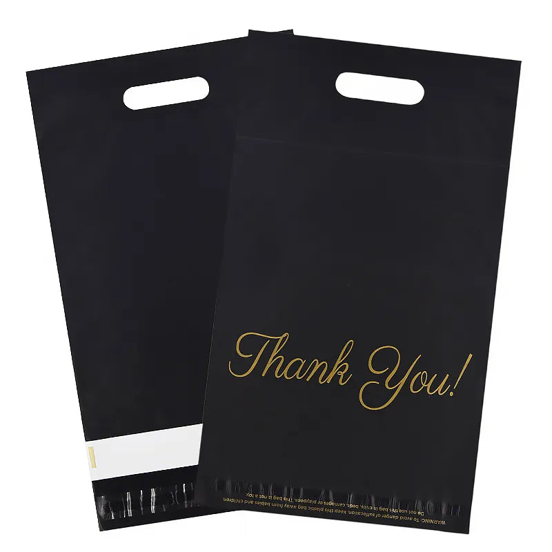 Two black die-cut handle mailer bags with gold Thank You lettering and a white peel-off closure strip