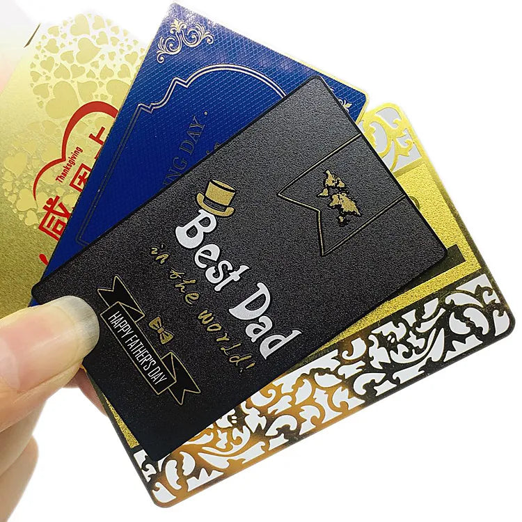 Fan of black and gold-tone metal business cards held in one hand