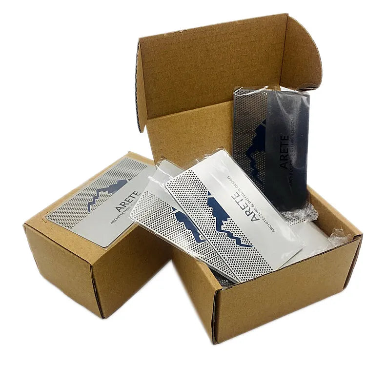 Black and silver-tone printed metal business cards packed in open cardboard boxes