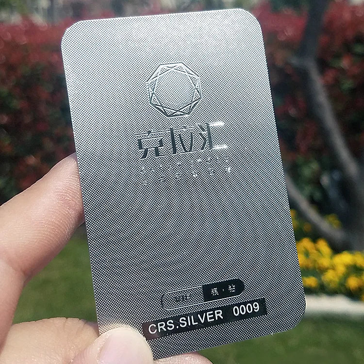 Gray metal card with embossed-style branding and a QR code near the lower edge
