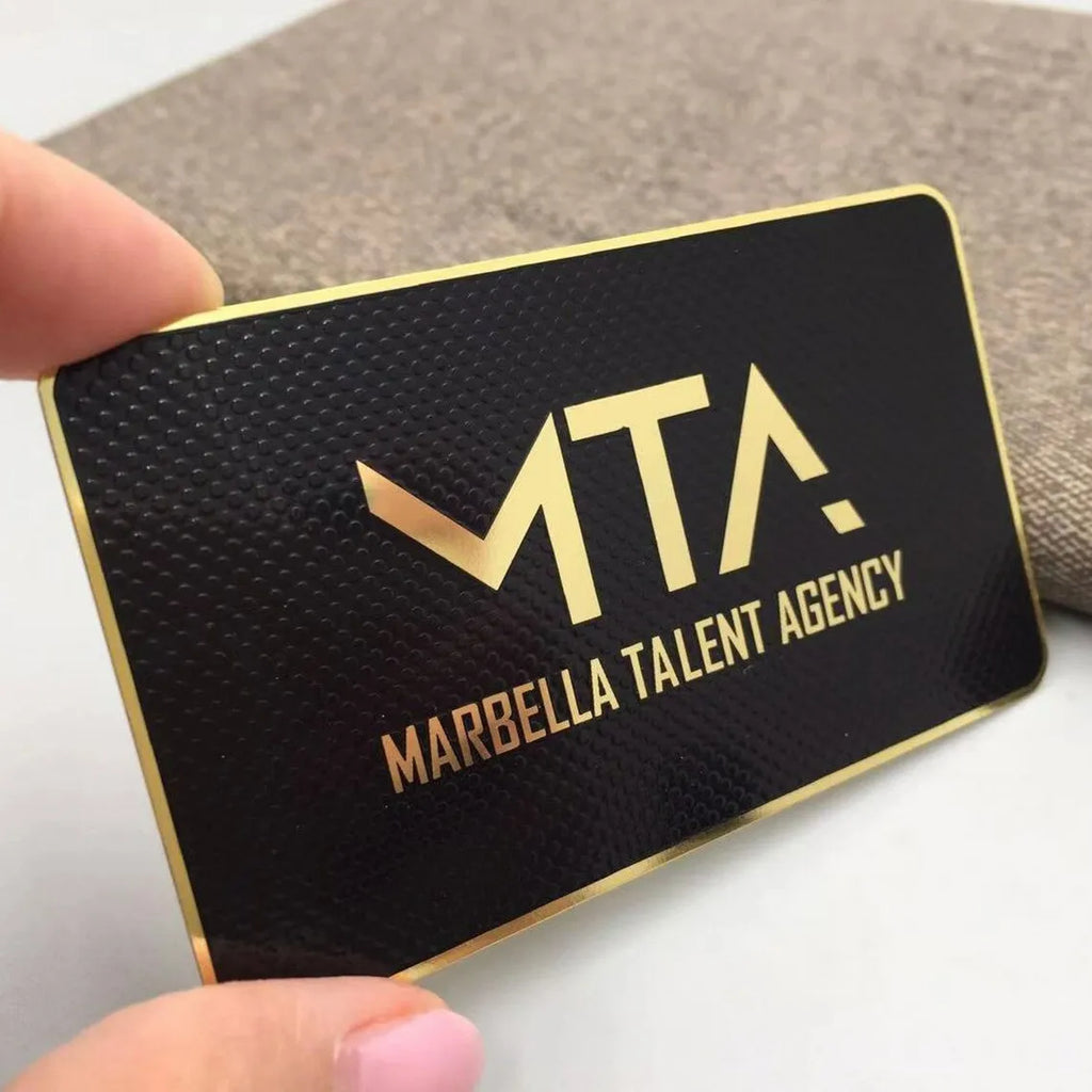 Black metal business card with gold-tone MTA lettering and rounded corners