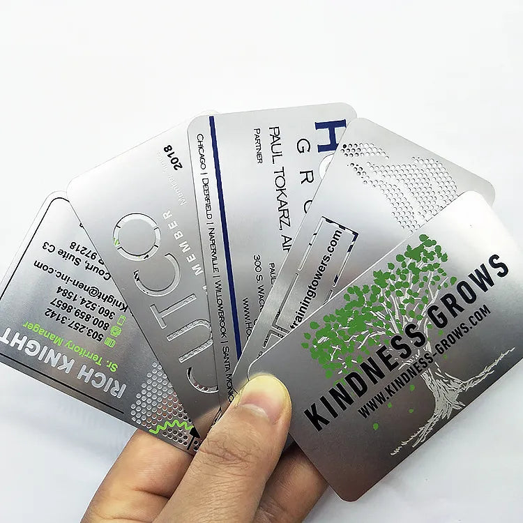 Fan of silver-tone metal business cards with printed names and contact details