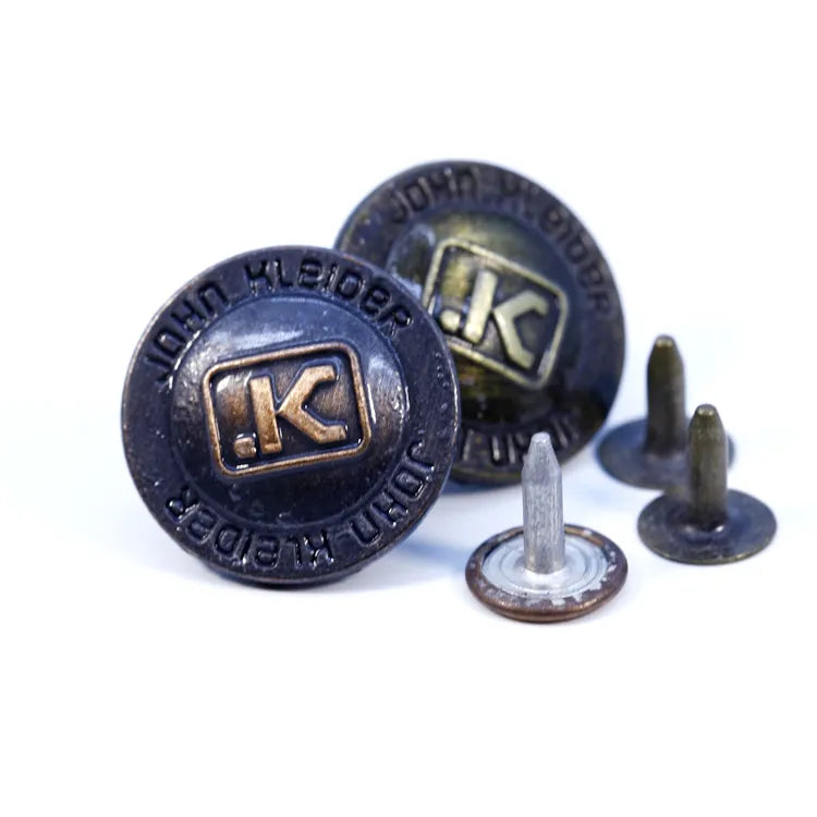 Assorted custom antique brass alloy metal jeans buttons with raised lettering and engraved brand logos