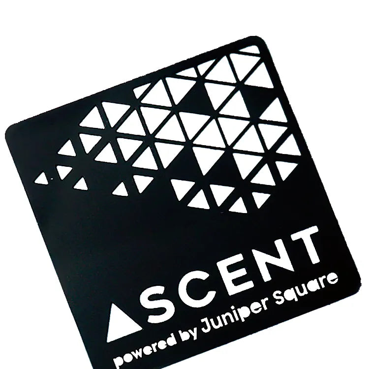 Black metal business card with triangular cutouts and ASCENT lettering on a white background