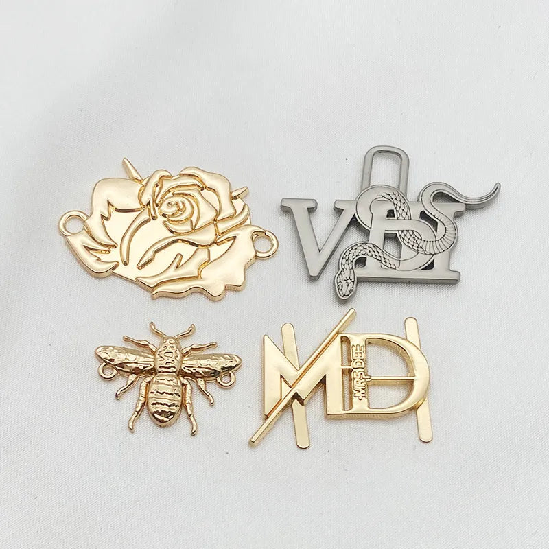 Collection of 3D custom logo metal badges including rose, lock, bee and monogram designs