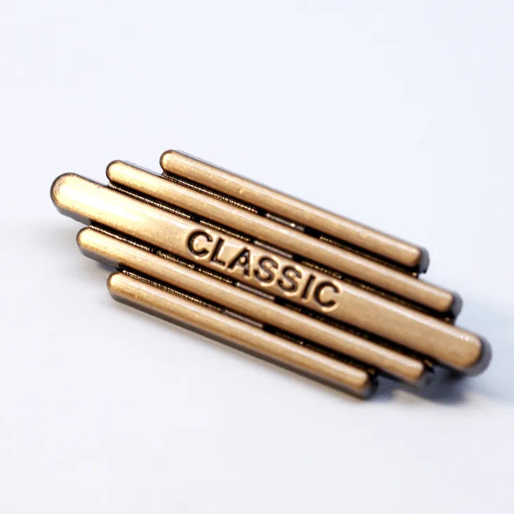 Polished brass-tone multi-tier geometric metal badge with engraved Classic lettering for fashion garments