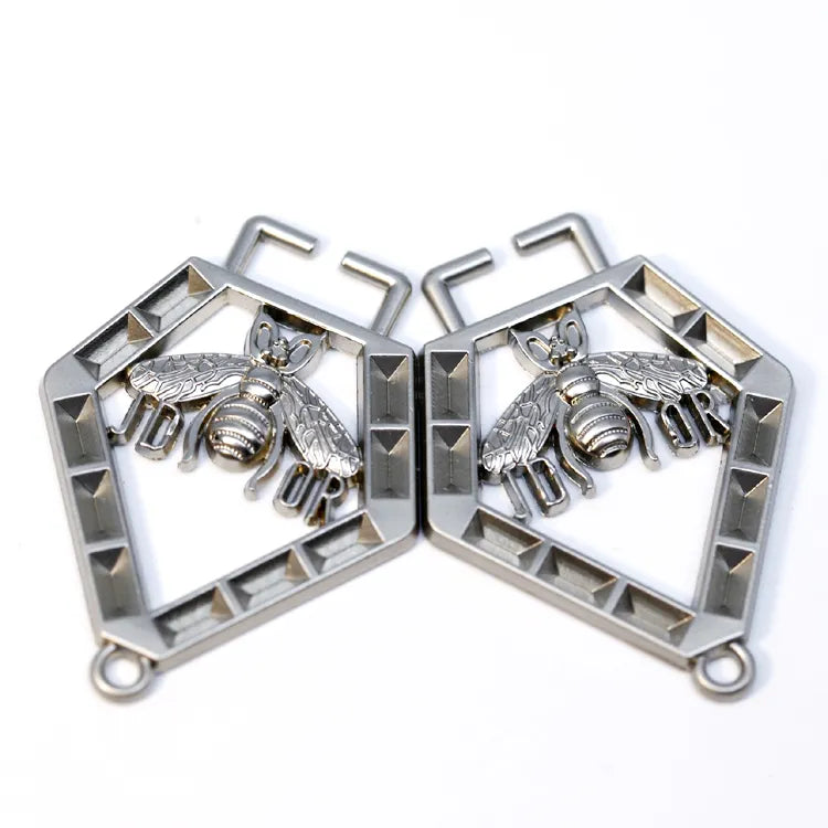 Openwork honeycomb pentagon metal logo badge featuring a bee emblem and brand lettering