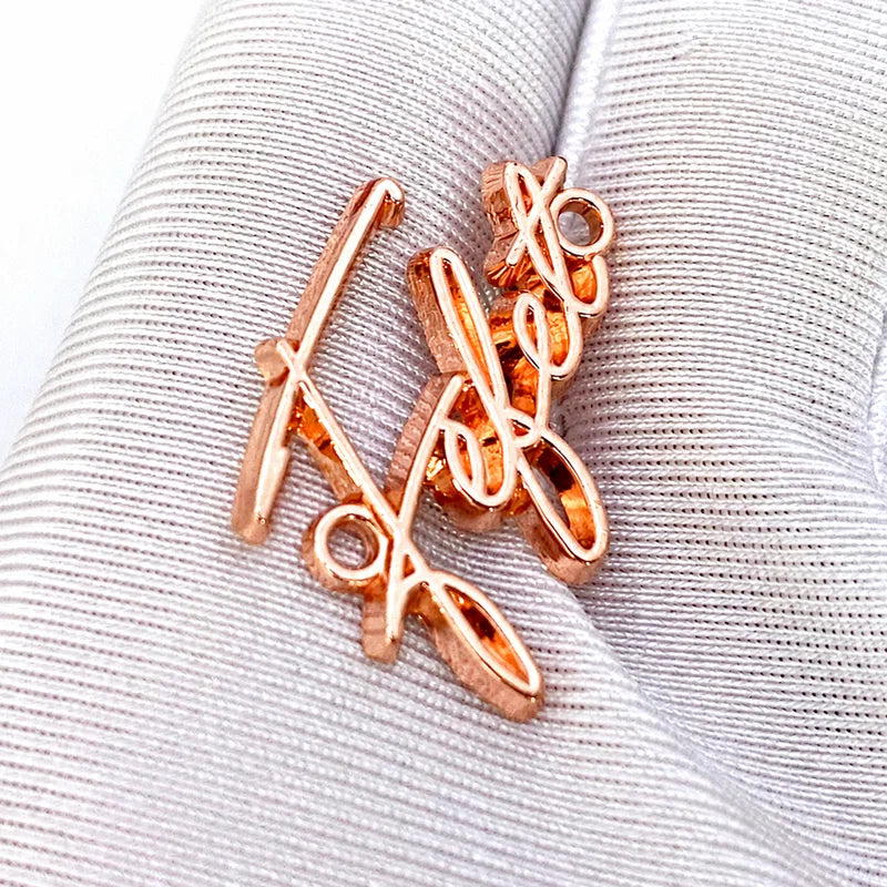 Custom rose gold metal script logo badge held in hand showcasing high polish finish
