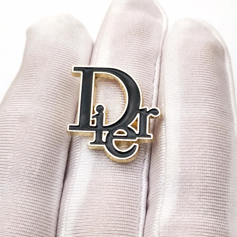 Custom gold metal letter emblem with black enamel fill for designer handbags and leather goods