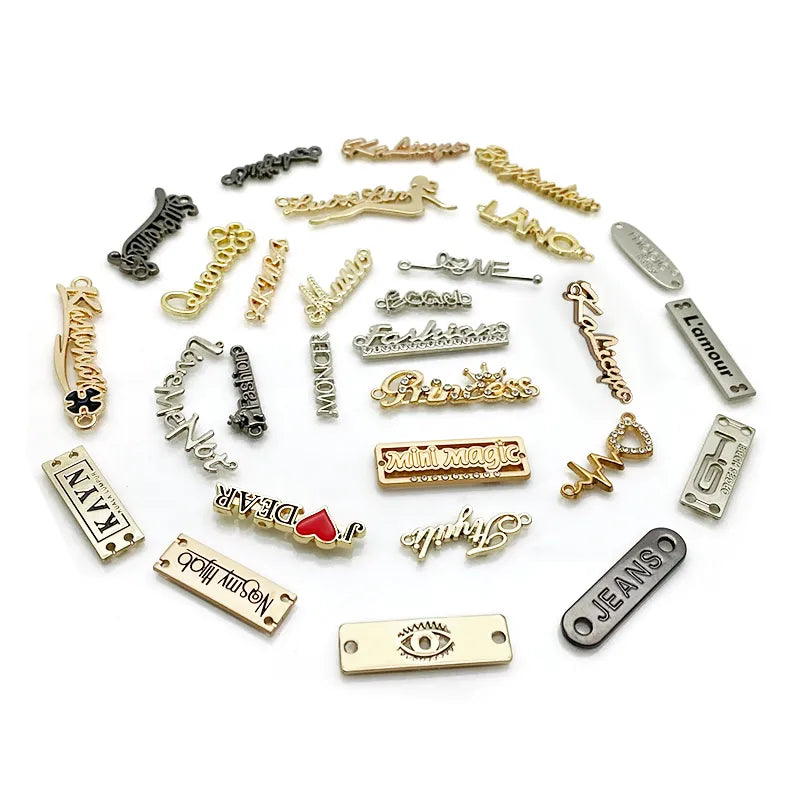 Curved gold branded metal tag for jeans with side attachment holes held in gloved hand