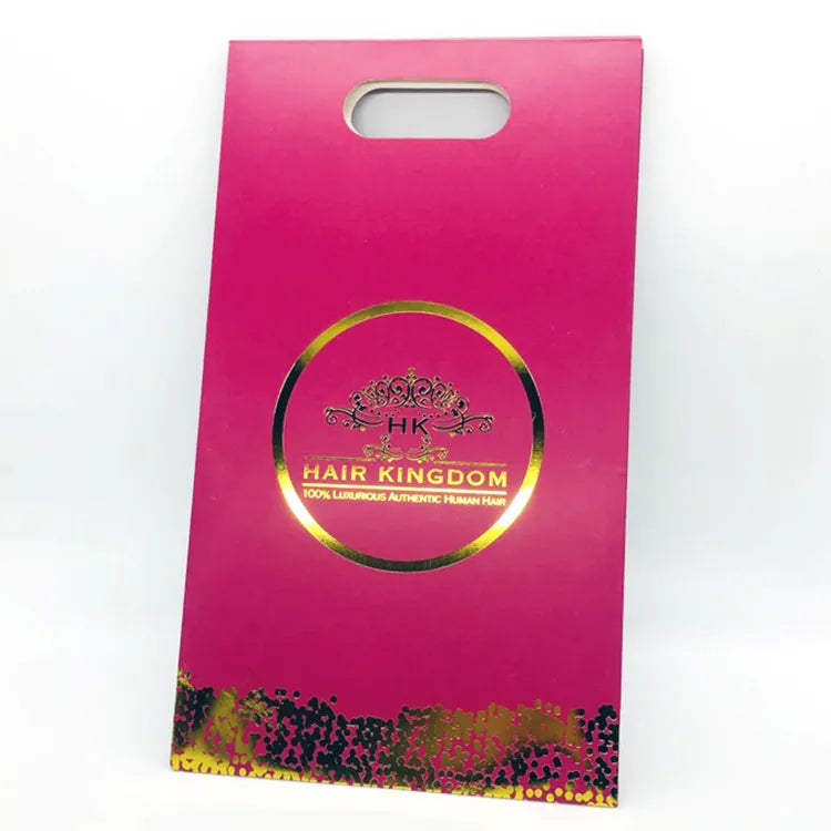 Pink paper bag with a die-cut handle and decorative print along the bottom