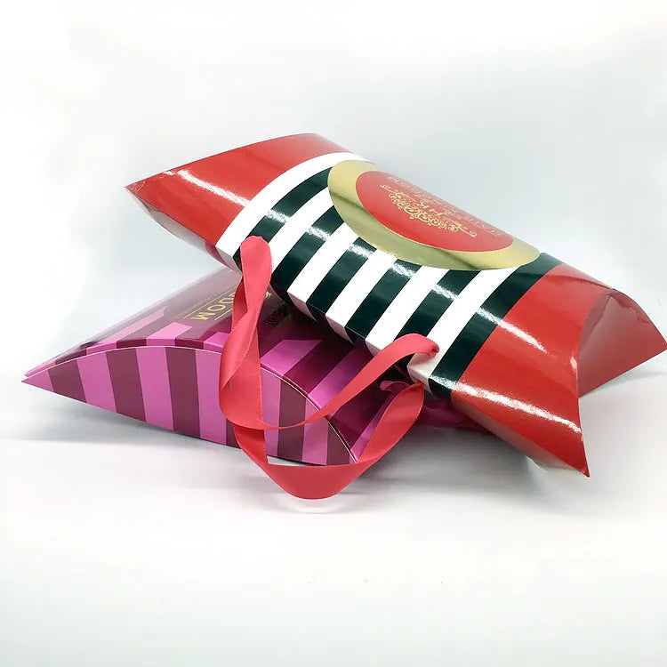 Colorful pillow-shaped paper gift bags with striped prints and ribbon handles