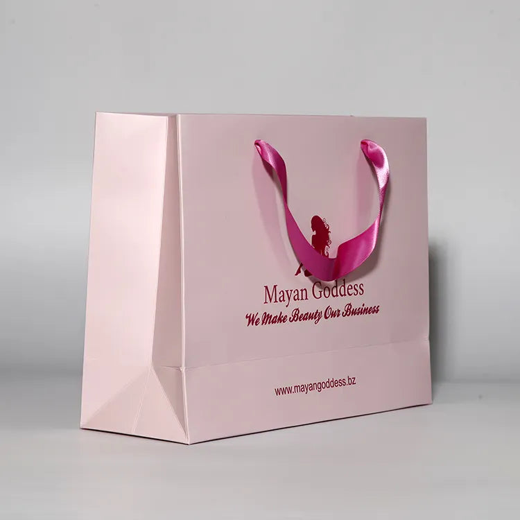 Pink paper shopping bag with matching ribbon handles and a printed logo