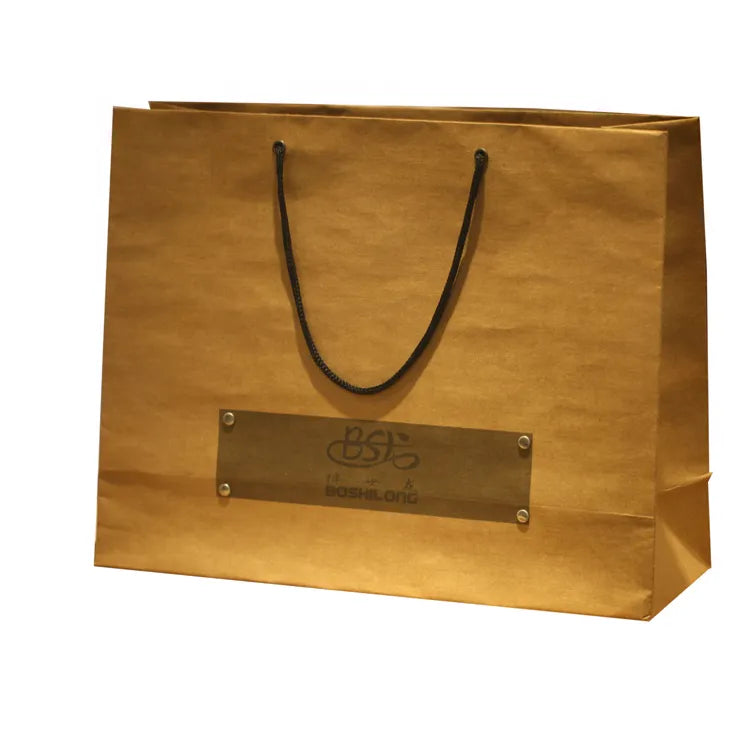 Brown paper carrier bag with dark cord handles and a rectangular printed label