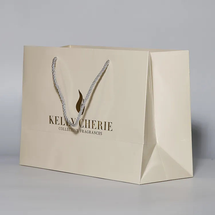 Cream-colored paper shopping bag with matching cord handles and a printed logo