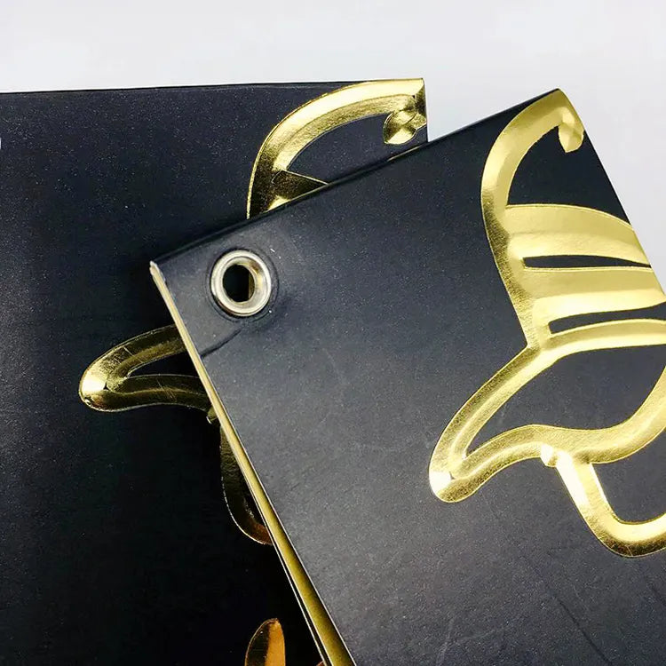 Black hang tag with metallic gold script and round metal eyelet