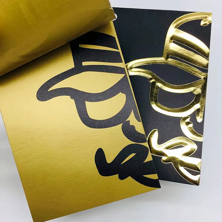 Black and metallic gold card samples showing large foil lettering and raised decorative impressions