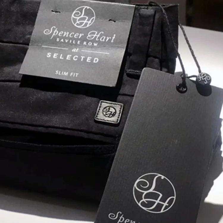 Grey printed logo hang tags displayed with dark trousers