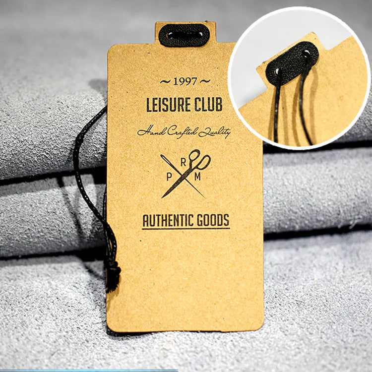 Brown kraft style clothing hang tag with black printing, raised attachment tab and black string detail
