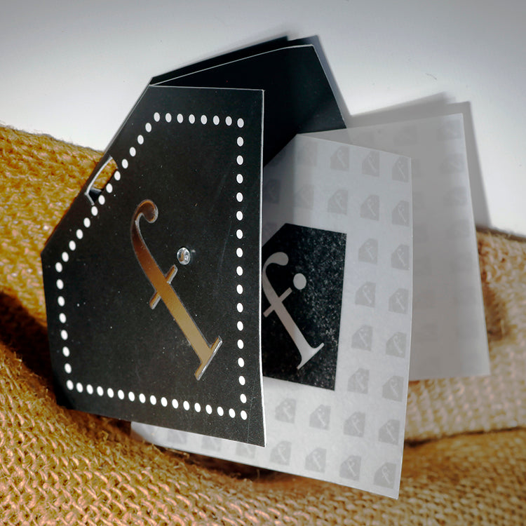 Custom Die-Cut Black Glitter Hang Tag - Pentagon black glitter card with white dot border, gold foil initial and frosted translucent overlay