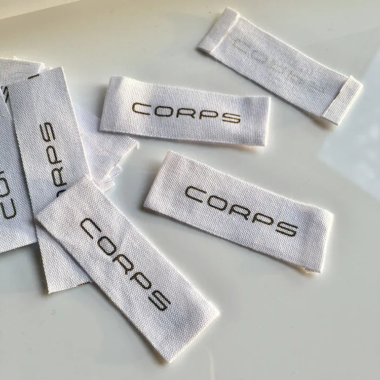 White end-fold clothing labels with gray FORCE brand lettering