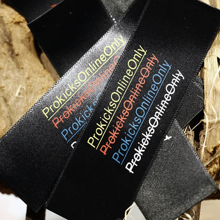 Black ribbon labels with multicolored brand text and decorative lettering
