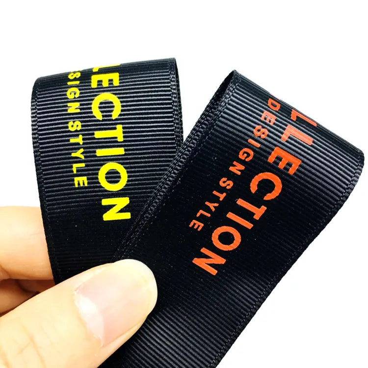 Black ribbed ribbon labels with vertical yellow and orange brand lettering