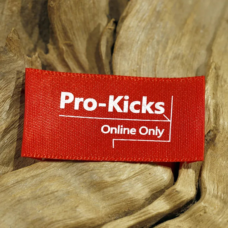 Red rectangular clothing label with white Pro-Kicks lettering on olive fabric