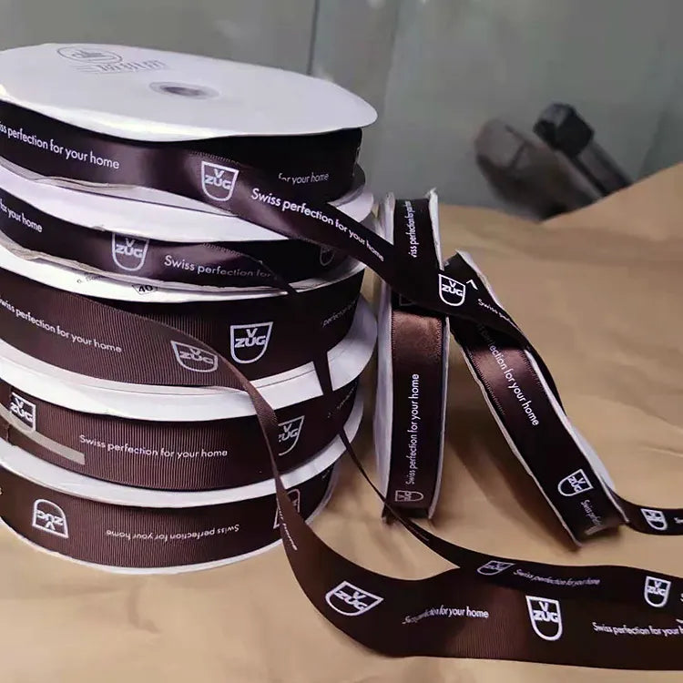 Custom branded packaging ribbon with unrolled printed tape demonstrating continuous logo repeat