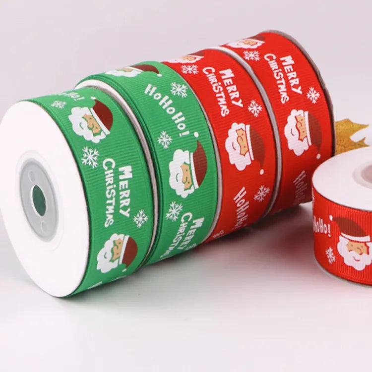 Festive red and green Christmas ribbon rolls printed with Santa Claus and holiday greetings