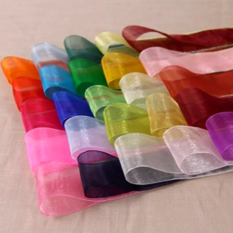 Multi-color sheer fabric ribbon rolls arranged in a vibrant pastel and bright color stack