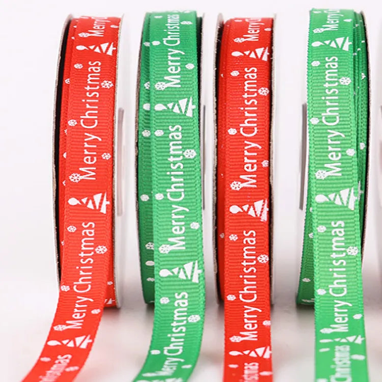 Skinny red and green satin ribbon rolls with delicate white holiday tree and snowflake motifs