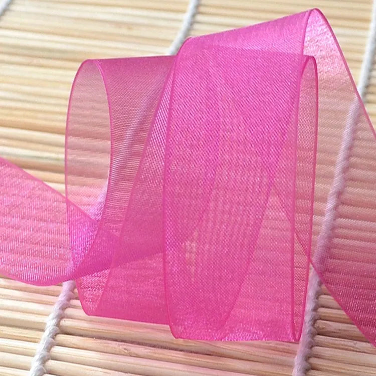 Vibrant magenta sheer fabric ribbon loop highlighting translucent weave and clean edge finish