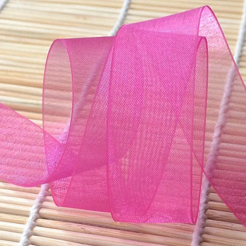 Vibrant magenta sheer fabric ribbon loop highlighting translucent weave and clean edge finish