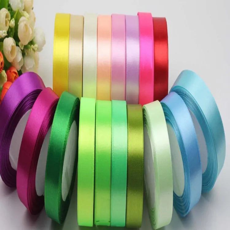 Multi-color solid satin ribbon rolls in rainbow assortment for gift packaging and crafting