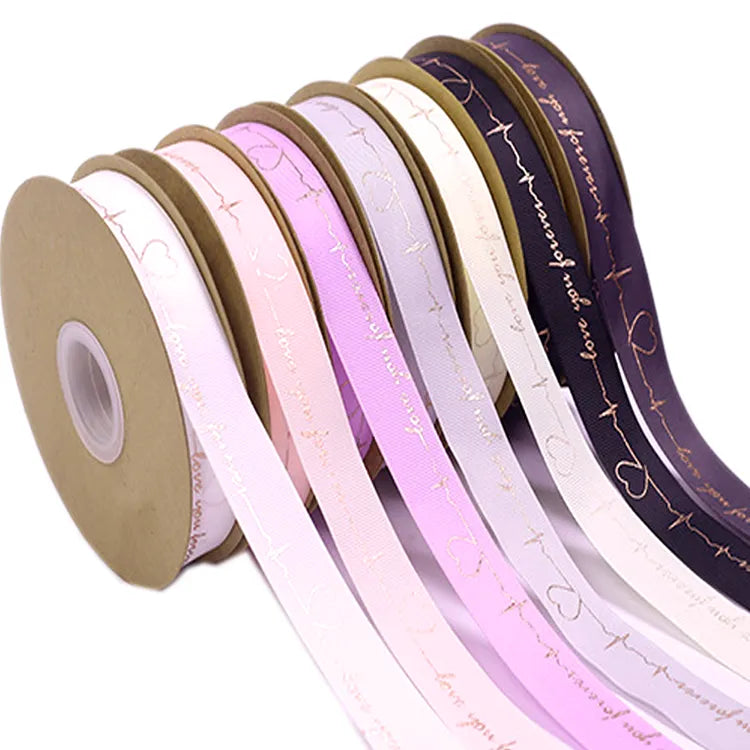 Romantic script printed satin ribbon rolls in pastel shades for wedding and celebration favors
