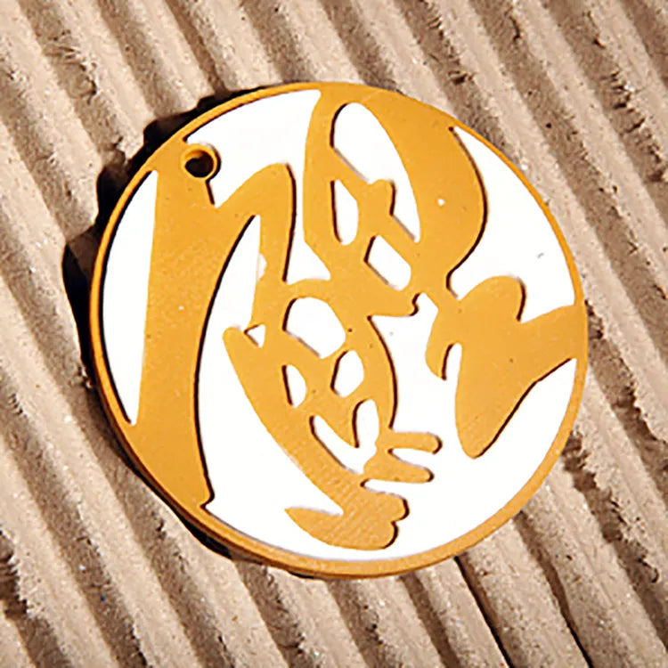 Close-up of a custom round yellow and white silicone rubber keychain pendant with a cartoon character design