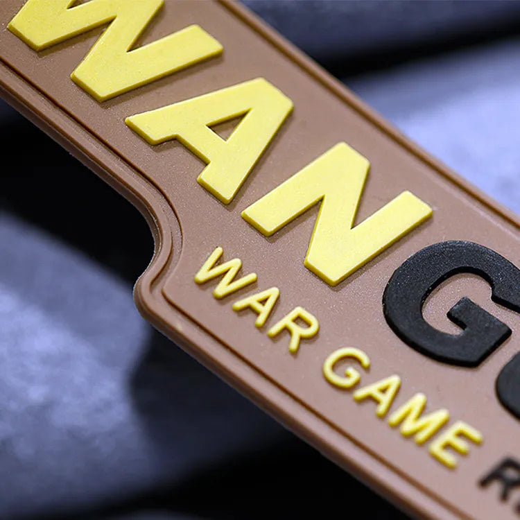 Close-up of tan rectangular rubber patch with raised yellow and black lettering