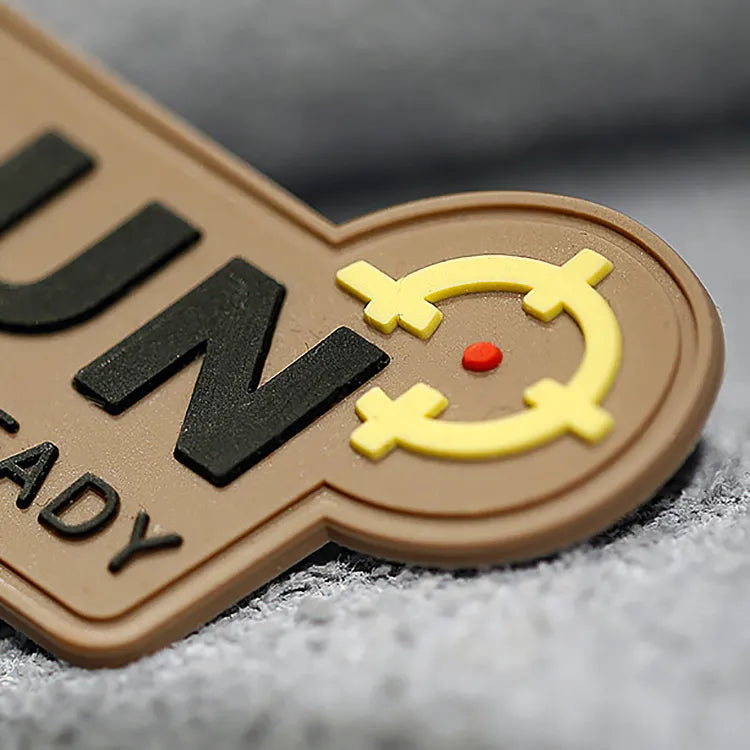 Close-up of a custom tactical PVC rubber morale patch with raised lettering and a yellow target symbol