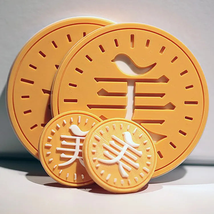 Yellow circular rubber logo patch with cutout details and raised edges