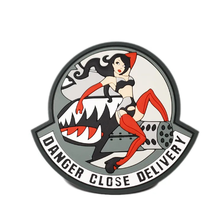 Round rubber badge with a red, black and white shark illustration