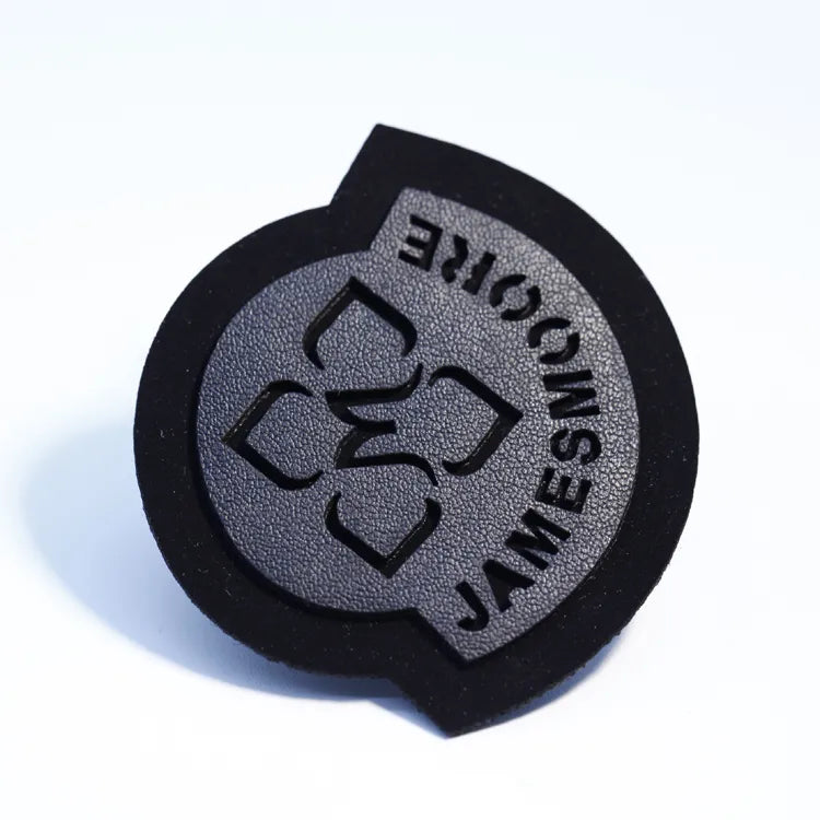 Round black and grey rubber logo badge with raised lettering