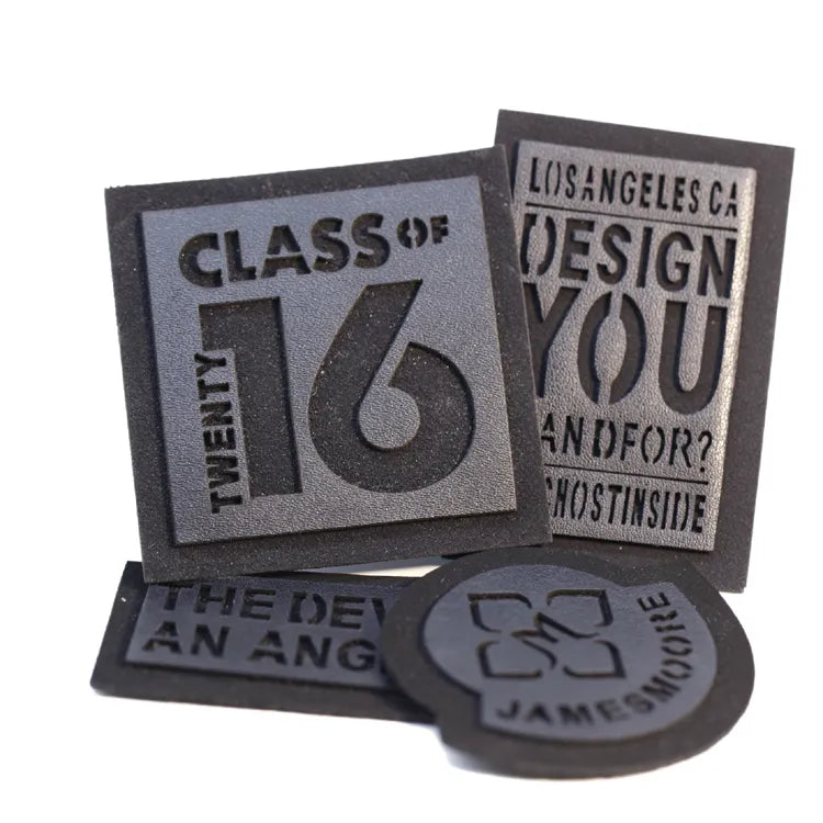 Assorted dark molded brand patches with raised lettering and rectangular shapes